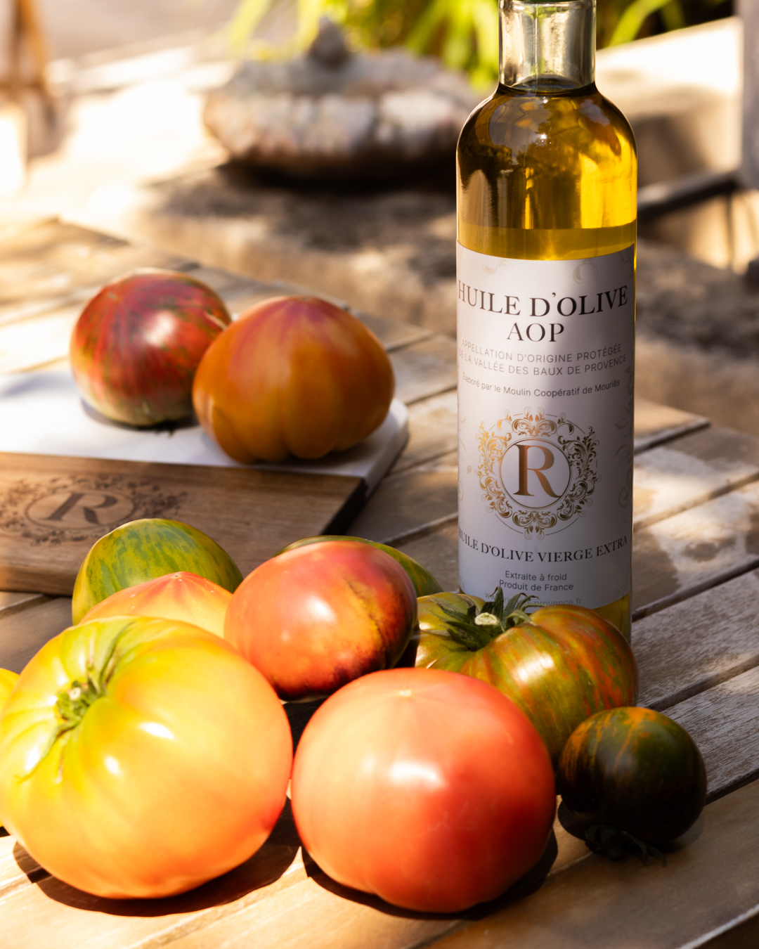 Shooting produit à Mollégès : Huile d'olive et graphisme d'étiquettes pour réseaux sociaux et site web Bouteille d'huile d'olive et tomates, capturées lors d'un shooting produit à Mollégès pour réseaux sociaux et site web avec graphisme des étiquettes